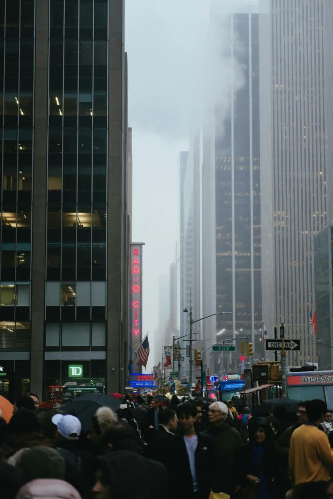 A hazy view of a crowded Manhattan street with skyscrapers obscured by urban pollution during the February 18 2026 air quality alert.