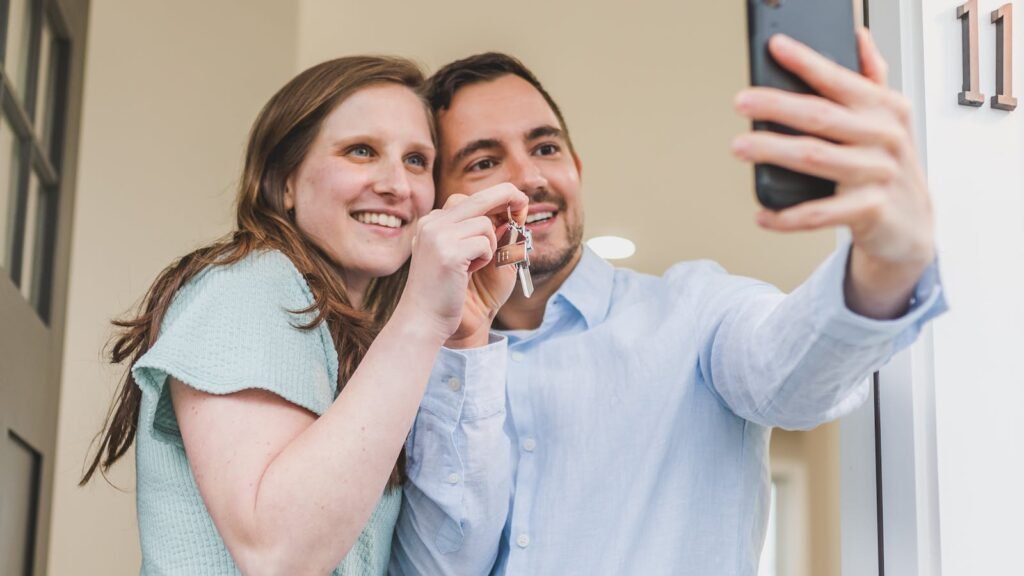 Young couple celebrating with keys to their new first home, illustrating the Gen Z homeownership trend